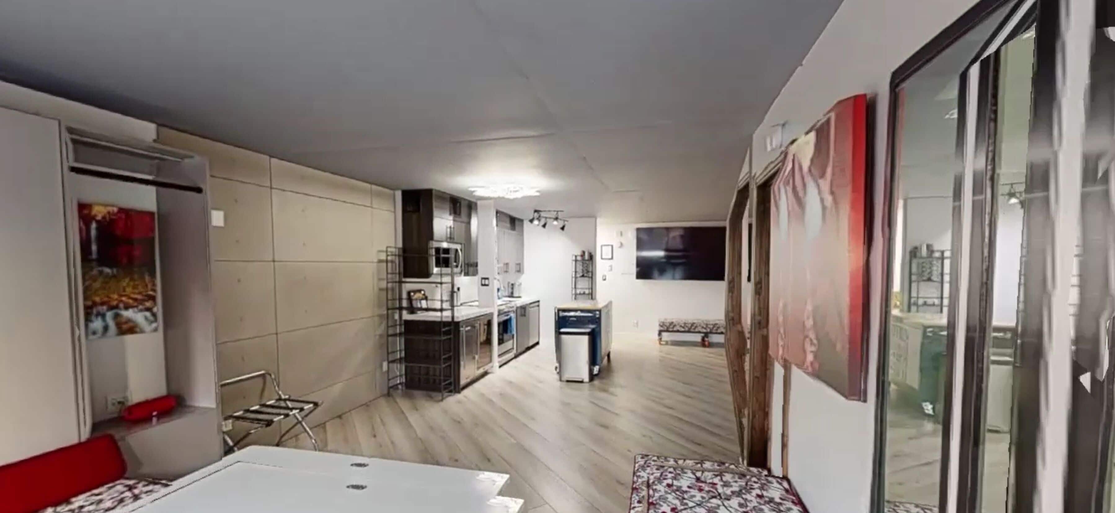 A compact living space with a kitchenette, a dining area, and a small seating area.