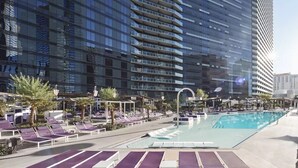 A modern hotel with a rooftop pool area, including sun loungers and a clear view of the surrounding buildings.