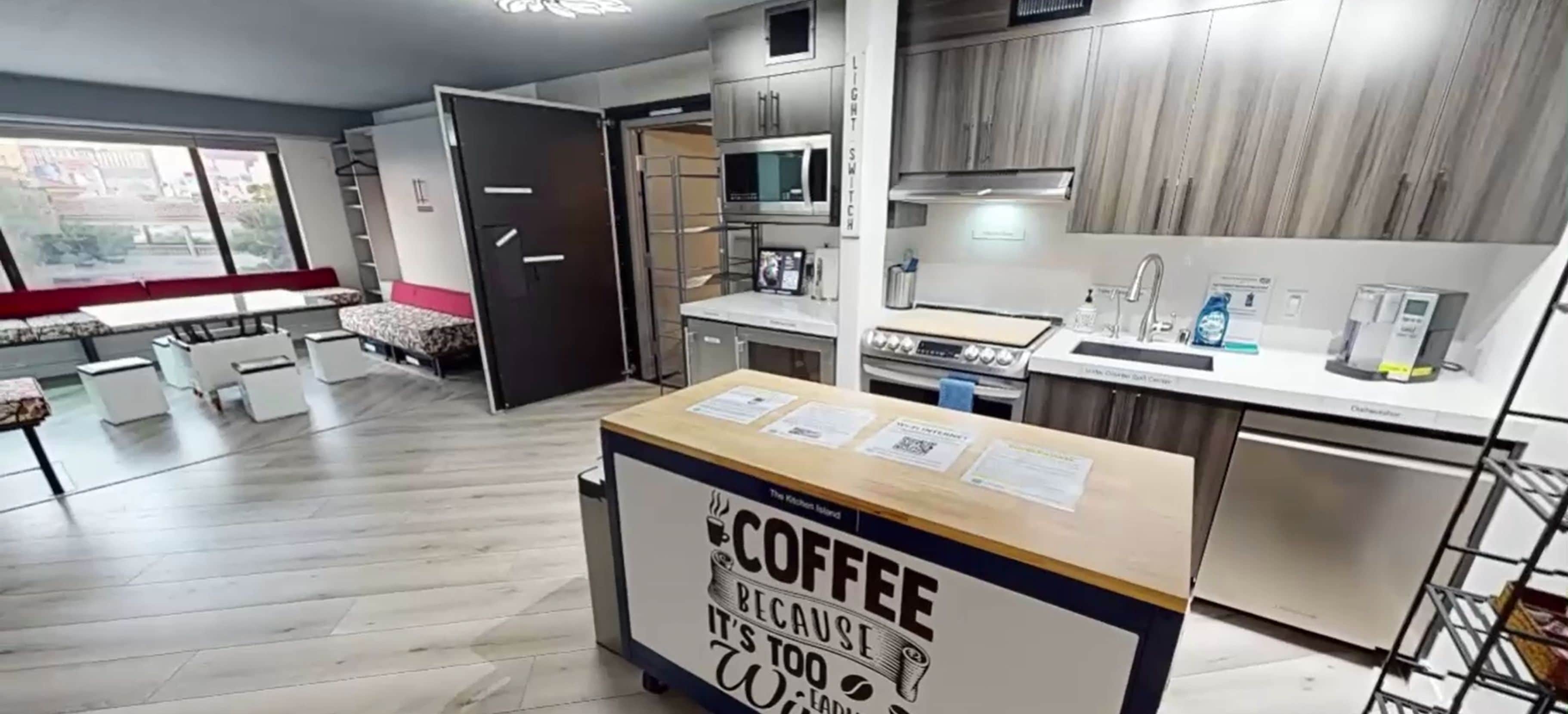Une cuisine moderne équipée d’un espace pour préparer le café, d’un four à micro-ondes et d’un évier.