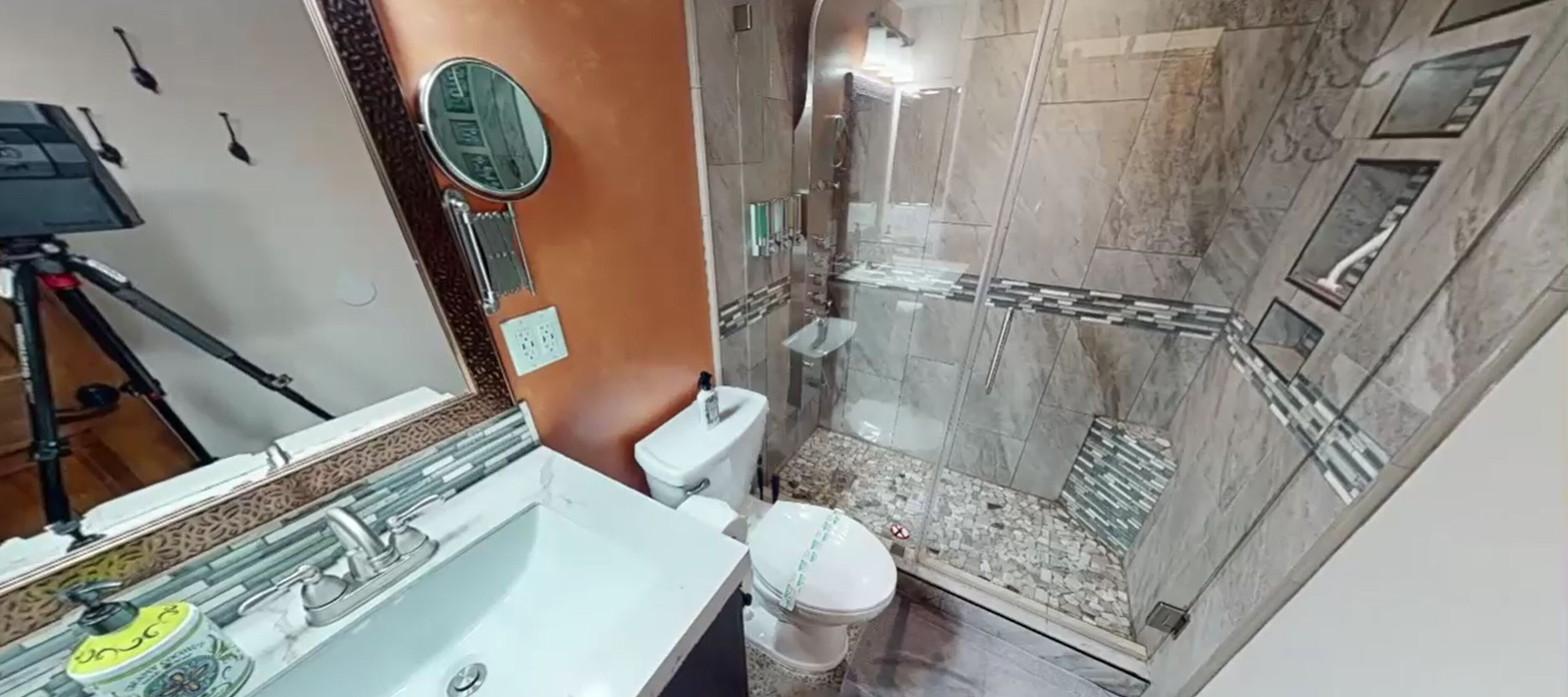 Une salle de bain avec douche, toilettes et lavabo.