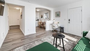 A modern apartment with a kitchen, dining area, and living room.
