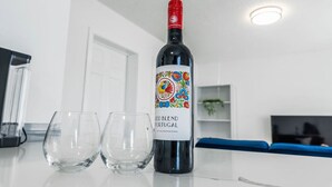 Una botella de vino tinto Red Blend de Portugal sobre una encimera de cocina con dos copas vacías a su lado.