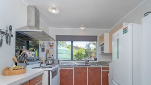 Una cocina moderna con electrodomésticos de acero inoxidable, armarios de madera y un amplio ventanal con vistas al exterior.