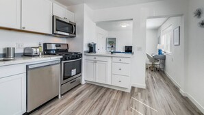 A modern kitchen with white cabinets, stainless steel appliances, and a wooden floor. - Fresh 1BR/1BA in Downtown Tacoma - 2 (Tacoma)