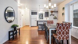 Una cocina moderna con gabinetes blancos, una isla central e iluminación colgante.