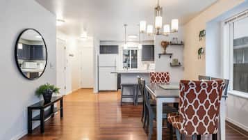 A modern kitchen with white cabinets, a central island, and pendant lighting.