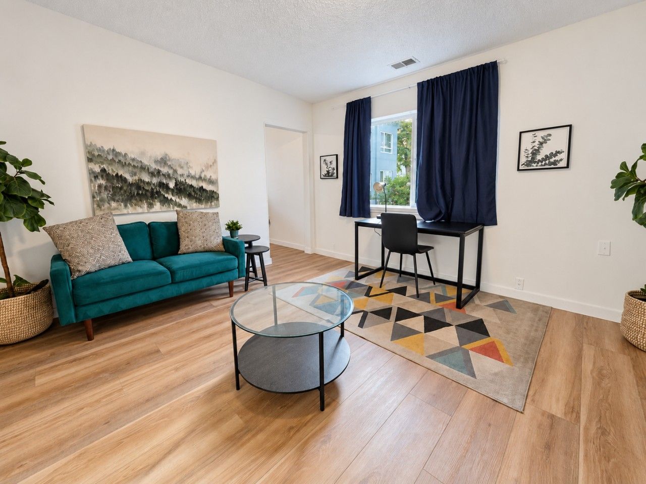 Ein Wohnzimmer mit Sofa, Couchtisch und einem Essbereich mit Stühlen und Tisch.
