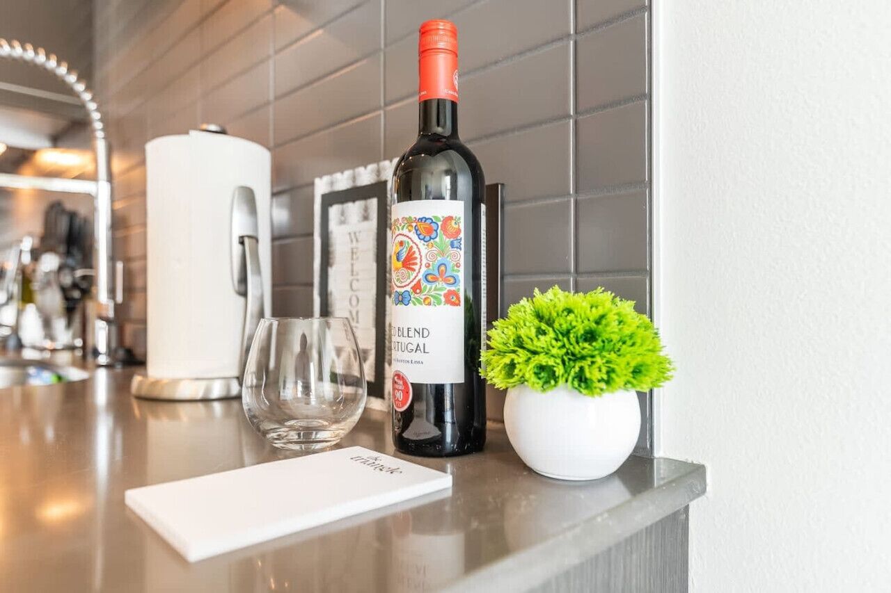 A wine bottle labeled "Blend Portuguese" on a countertop with a glass and a small potted plant.