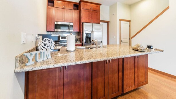 A kitchen with wooden cabinets, stainless steel appliances, and a granite countertop.