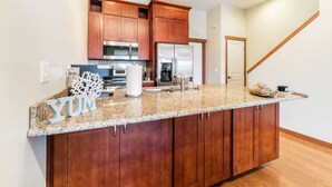 A kitchen with wooden cabinets, stainless steel appliances, and a granite countertop.