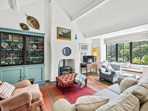 Una sala de estar acogedora con chimenea, asientos cómodos y vistas al exterior.
