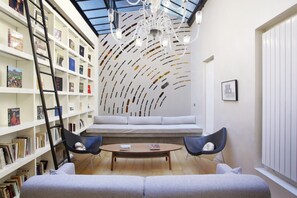 A cozy reading nook with a bookshelf, a cushioned bench, and a coffee table. - Superb Loft Center of Paris (Paris)