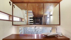 Un baño con tocador de madera, un espejo grande y un lavabo moderno.