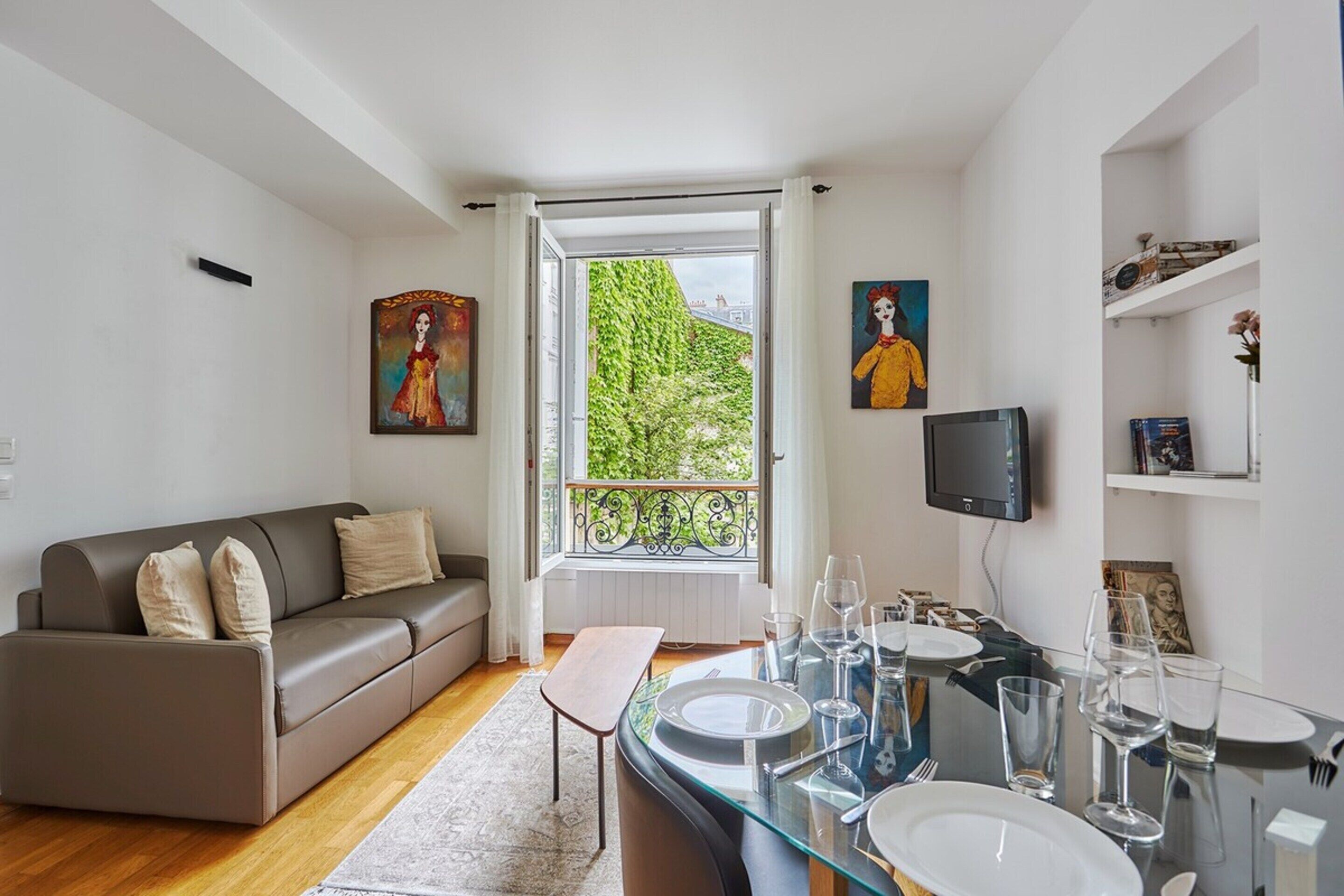 Ein modernes Wohnzimmer mit einer Couch, einem Esstisch und Kunstwerken.