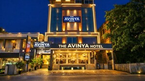Ett hotell med en tydlig skylt som visar texten ”The Avinya Hotel”, och en reception som syns vid ingången.