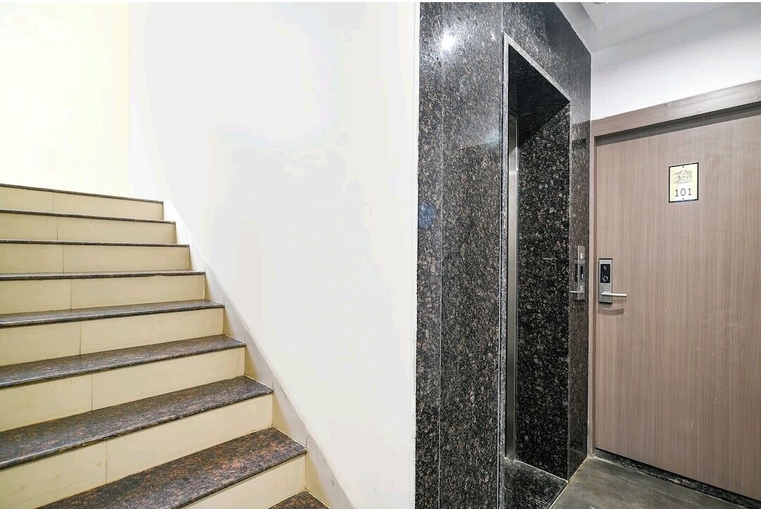Un escalier avec une rampe et une porte portant un numéro.