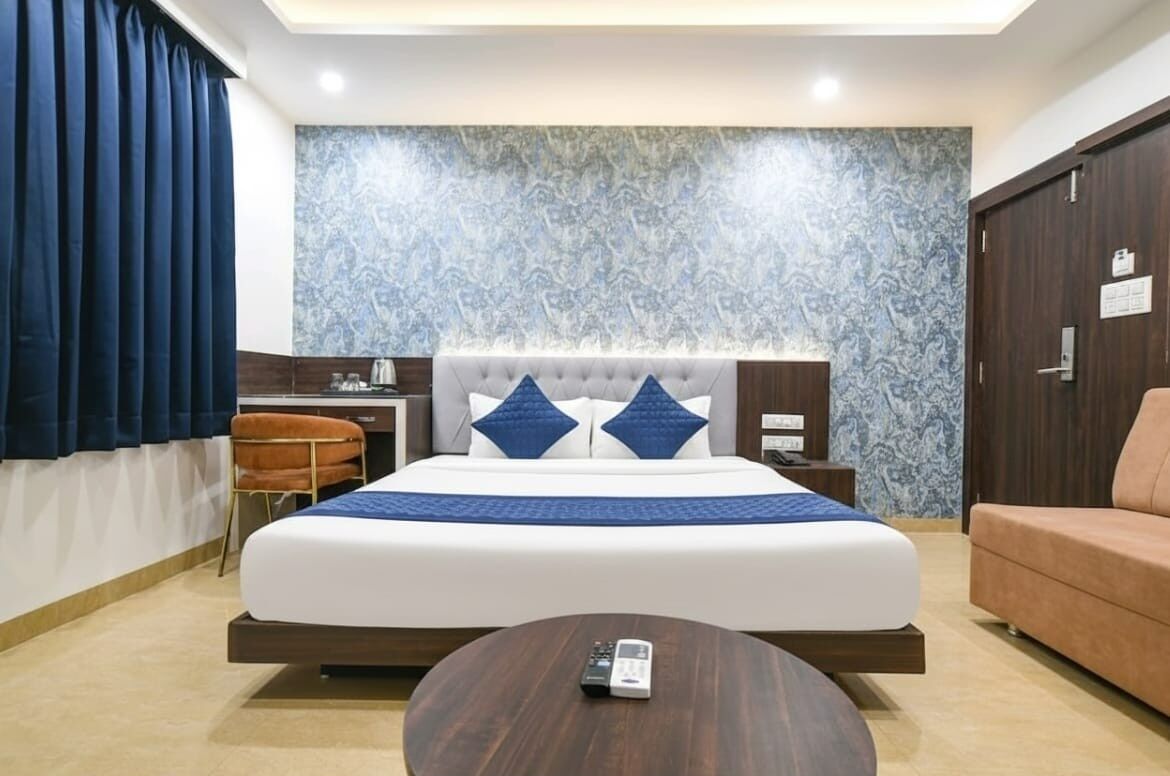 Una habitación de hotel moderna con una cama grande, un escritorio, una silla y un sofá.