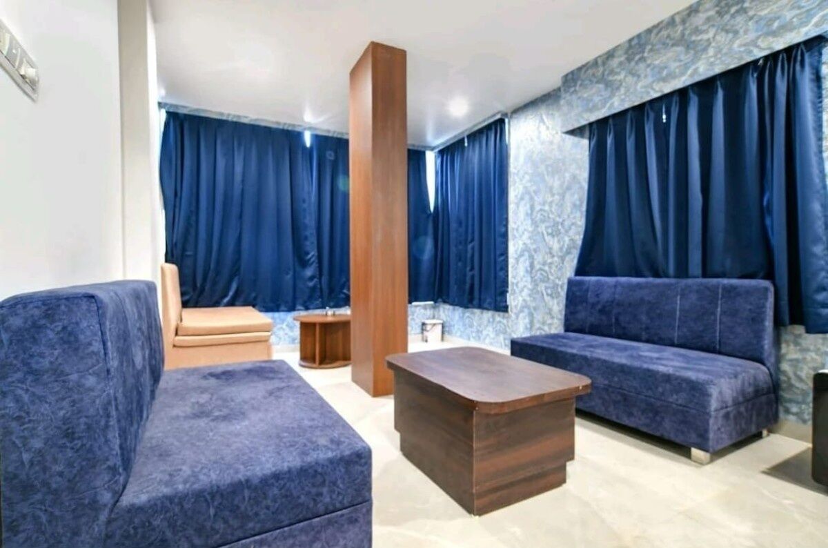 A modern living room with a sofa, a wooden coffee table, and a blue accent wall.