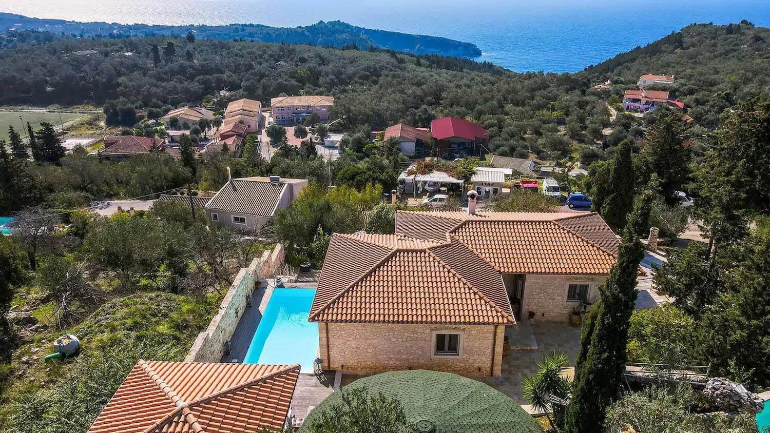 Zona residencial con casas, una piscina y vistas al mar.