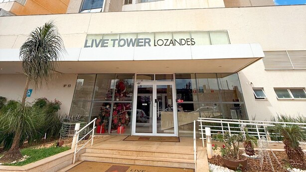 Ένα ψηλό κτίριο με μια επιγραφή που γράφει: «LIVE TOWER LOZANDES».