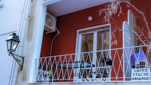 A balcony with a white railing, a table, and a chair. - Plaka Apartment (Athens)