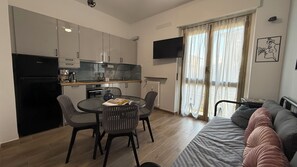 A compact living space with a kitchenette, dining area, and a sofa.