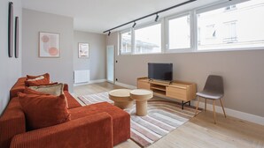 A modern living room with a sofa, coffee table, and TV stand. - Sublime and new Apartment Le Marais / Beaubourg (Paris)
