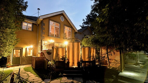 A two-story house with a stone pathway leading to the front door, a wooden bench, and a fenced backyard. - Specious one bedroom apartment in upscale neighbourhood in Leaside Toronto.  (Toronto)