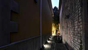 A narrow alleyway with a yellow building on one side and a brick wall on the other. - Specious one bedroom apartment in upscale neighbourhood in Leaside Toronto.  (Toronto)