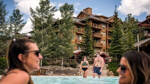 Un complexe hôtelier avec des bâtiments en bois, une piscine et des arbres environnants.