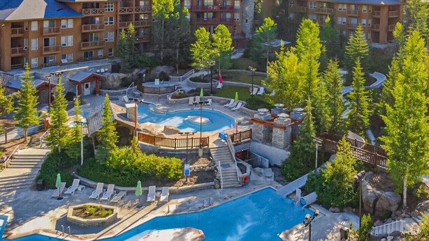 Un complexe hôtelier comprenant plusieurs bâtiments, un espace piscine central et de nombreux espaces verts environnants.