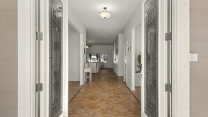 A hallway with a tiled floor, white walls, and a ceiling light. There are doors with intricate designs on the sides. - Private spacious resort, jumbo heated salt water pool/spa, game room, office (Navarre)