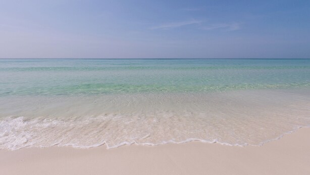 A beach with clear turquoise water and a sandy shore. - Private spacious resort, jumbo heated salt water pool/spa, game room, office (Navarre)