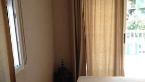 A hotel room with a bed, a window, and a door. - Residential apartment very close to the sea  (Blanes)