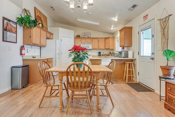 Una cocina moderna con armarios de madera, una isla central y una mesa de comedor con sillas.