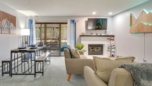 Ein modernes Wohnzimmer mit einer Couch, einem Esstisch und einem Kamin.