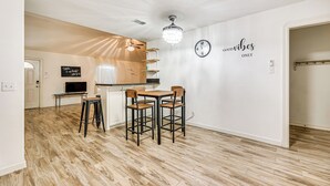 Une cuisine moderne avec un coin repas, un plancher en bois et un lustre.