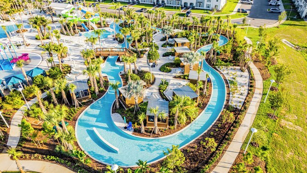 An aerial view of a resort with multiple swimming pools, palm trees, and a parking area. - Spacious 7BR Clermont Retreat w/ 4 King Beds, Modern Comfort & Great Location (Clermont)