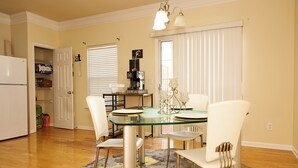 A dining area with a glass table, white chairs, and a patterned rug. - Charming 3-bedroom townhome in Duluth  (Duluth)