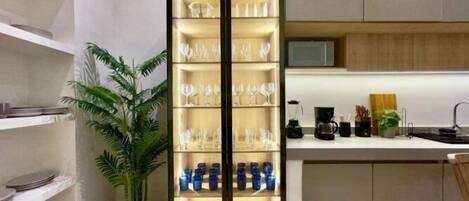 A modern kitchen with a built-in wine rack, a coffee maker, and a potted plant.