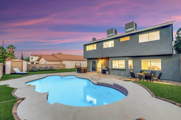 Relax in the backyard with a swimming pool and outdoor seating areas.
