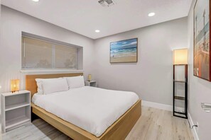Cozy retreat with a single bed, bedside table, and framed picture.