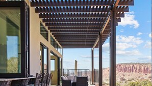 Un espacio al aire libre techado con patio, asientos y vistas al paisaje desértico.