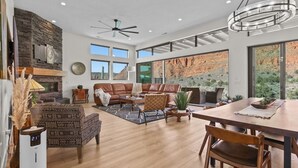 Ein geräumiges Wohnzimmer mit Kamin, Ledersofas und einem Essbereich mit Holztisch.