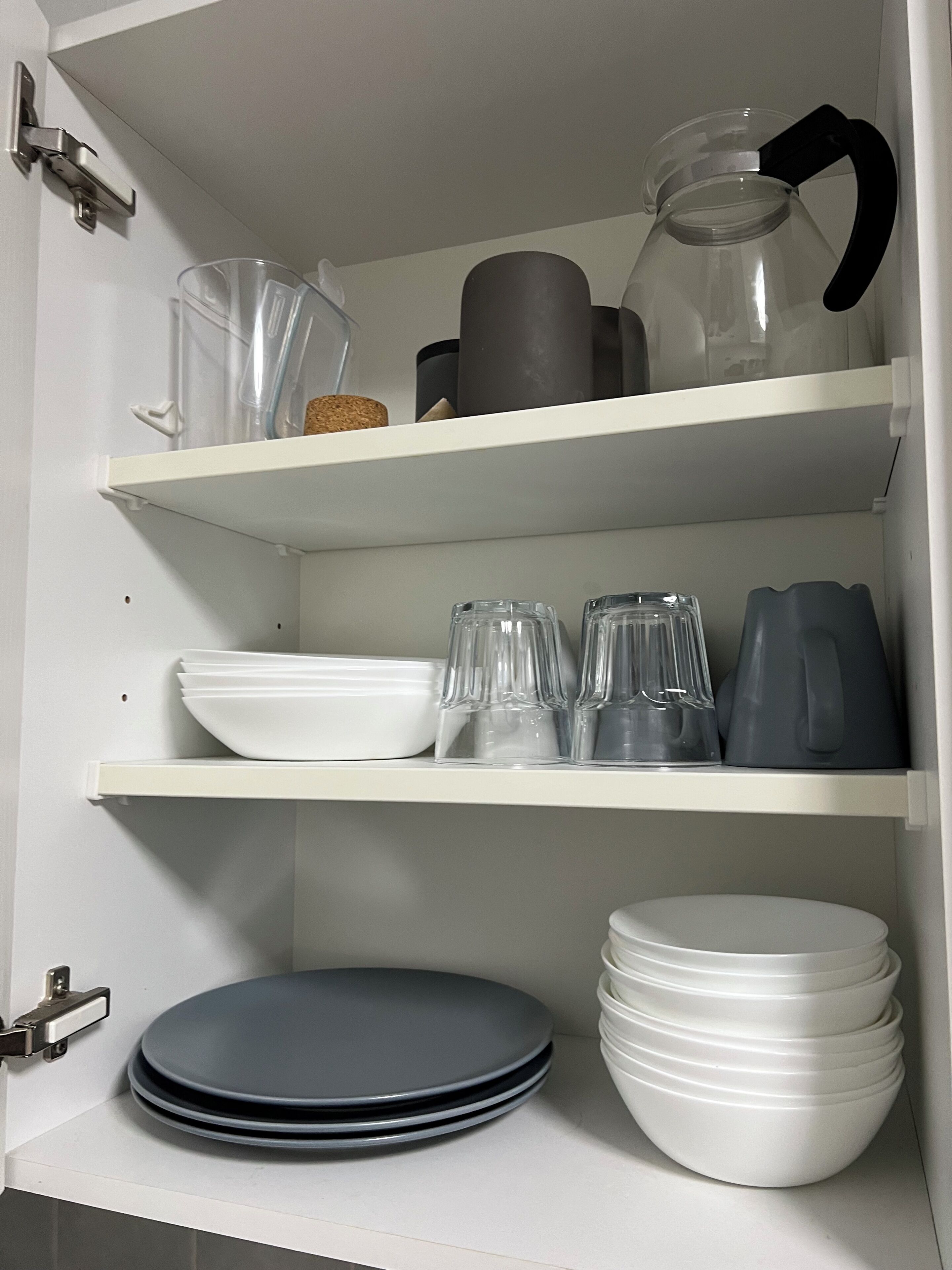 Un armario de cocina con repisas que contienen diversos utensilios de cocina.