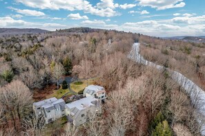 A remote house surrounded by dense forest and a winding river. - Ski-In/Ski-Out Condo with Private Deck, Kingswood (Quechee)