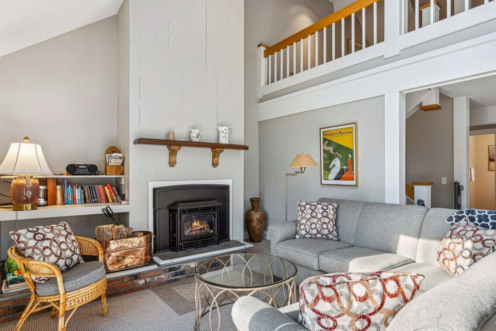 A living room with a fireplace, a sofa, a coffee table, and a bookshelf.