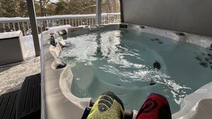 A hot tub on a covered deck with a view of trees and a clear sky. - Chain of Lakes Escape with Hot Tub & River Access! (Bellaire)