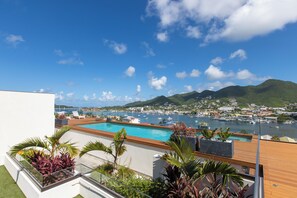 A rooftop pool with a view of a marina and mountains. - B206 - Magnificent 1 bedroom with terrace (Cole Bay)
