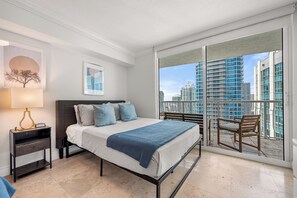A bedroom with a bed, bedside table, lamp, and a view of a cityscape through a balcony. -  Centric 40thFloor Brickell Condo FREE parking by Palermo Home Miami (Miami)